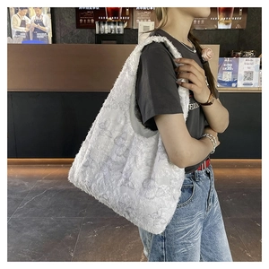 Detailed view of white fluffy tote bag featuring 3D butterfly patterns and plush texture