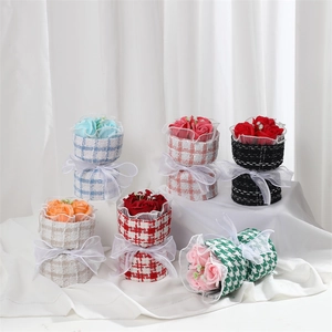 Close-up of assorted soap rose bouquets in stylish plaid fabric wrapping with silk ribbons