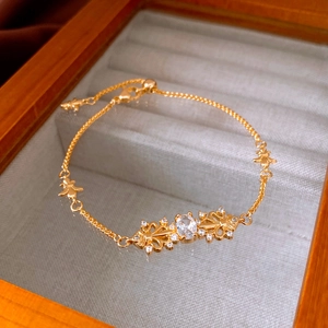 Macro detail of gold iris pendant bracelet with oval zircon in a linen jewelry box