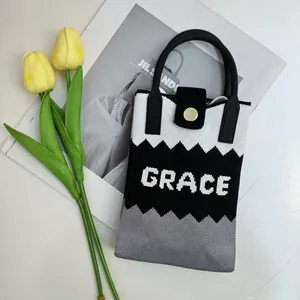 Close-up of tricolor knit tote bag with Grace lettering and elegant fashion props