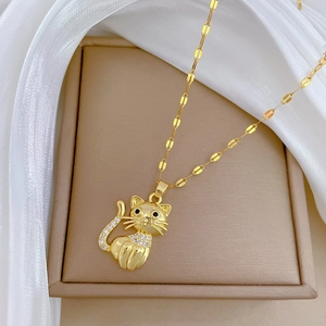 Macro view of a gold cat pendant with zircon stones on silk fabric in a jewelry box