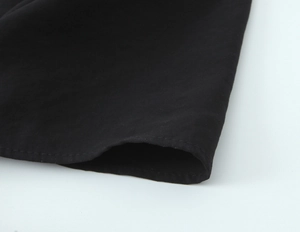 Macro shot of black fabric edge with double needle stitching and smooth plain weave texture