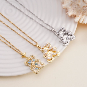 Bear pendant necklace set with colorful zircons and pearls on white ceramic plate