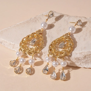 Elegant gold fringe earrings with teardrop crystals and round white pearls in baroque style