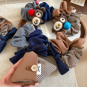 Close-up of retro fabric scrunchies with plaid patterns and cute plush bear ornaments