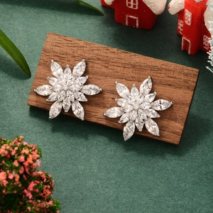 Sparkling zircon snowflake stud earrings displayed on a festive Christmas themed background