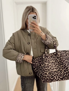 Detail of olive green quilted cotton jacket and leopard print tote bag for winter style