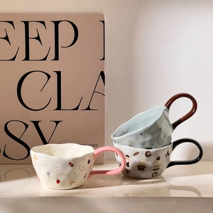 Detail of cute ceramic bear mug with irregular shape and colorful large handle