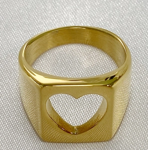 Minimalist gold hollow heart stainless steel ring on elegant white silk fabric