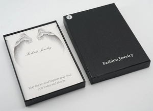 Détail boîte à bijoux noire texturée avec motifs d'ailes et texte Fashion Jewelry