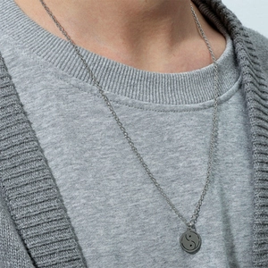 Detail of vintage silver Tai Chi Yin Yang pendant on a slim round link chain necklace