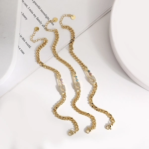 Three gold evil eye paperclip bracelets with micro-pave zircon on white decorative background
