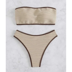 Dettaglio bikini beige con bordi marroni, tessuto a onde e slip a vita alta in mostra