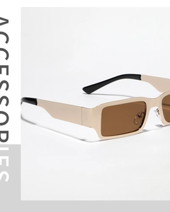 Macro shot of rectangular metal frame sunglasses with tea-colored lenses and gold finish