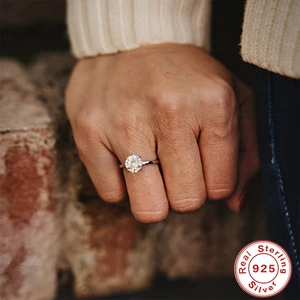Detailed view of sterling silver engagement ring with a round solitaire diamond on hand