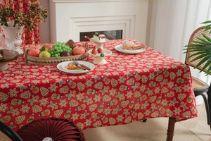 Close-up of red cotton linen tablecloth with Christmas gingerbread and snowflake patterns