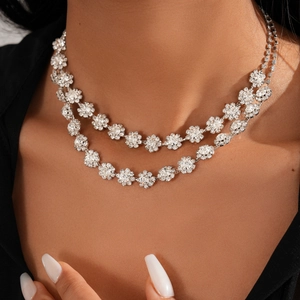 Detail of silver double-layer necklace with floral crystal pendants on a model