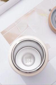 Detailed close-up of the SUS 304 food-grade stainless steel interior of a white thermos cup