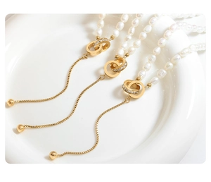 Detail of freshwater pearl necklaces with gold interlocking rings and zircon tassels
