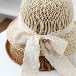 Elegant woven sun hats with floral ribbon bows in beige and caramel for summer travel