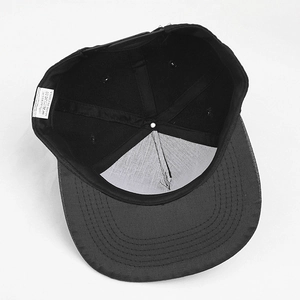 Internal view of black snapback hat showing 100% acrylic material and support lining