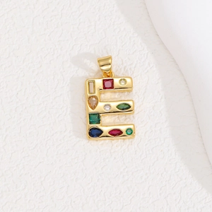 Macro view of golden letter E pendant with multi-colored crystals and zircon stones