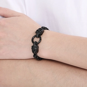 Close-up of punk style black skull link bracelet worn on wrist for a gothic aesthetic