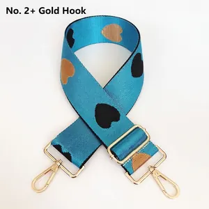 Detail of teal jacquard woven strap with heart pattern and golden adjustable metal buckle