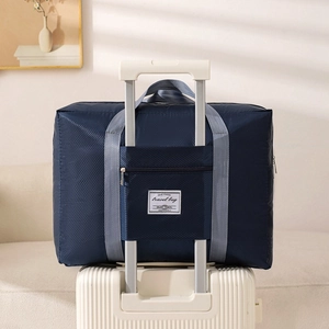 Waterproof navy quilted travel bag with trolley sleeve on white suitcase