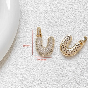 Detailed view of U-shaped gold-plated pendant with cubic zirconia and dimensions