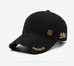 Detail of black cotton baseball cap with gold embroidery and metal logo badge