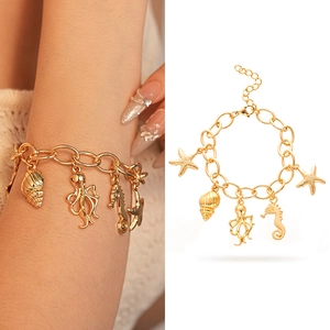 Close-up of golden ocean-themed bracelet featuring seahorse, starfish and shell charms