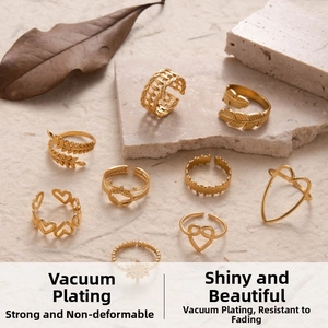 Close-up of golden stainless steel rings with leaf and heart shapes on textured background