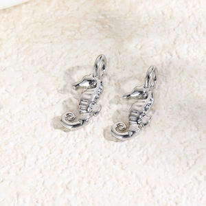 Macro detail of silver seahorse metal charms for DIY jewelry making with top connecting rings