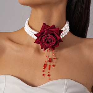 Détail du ras du cou rose rouge avec perles à trois rangs et glands en cristal rouge