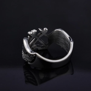 Vintage punk anchor wing ring in stainless steel with cross hollow design on black surface