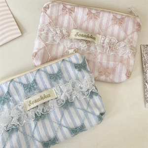 Close-up of lace floral coin purse showing striped fabric and delicate embroidery details