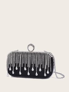Close-up of black evening clutch with silver rhinestone tassels and metal ring clasp