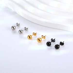 Three pairs of polished stainless steel ball stud earrings in silver, gold, and black