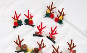 Flat lay of colorful Christmas reindeer antler hair clips with pine cones and berries