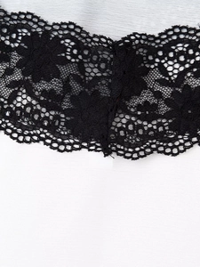 Vista macro dettagliata del pizzo floreale nero su supporto in tessuto bianco