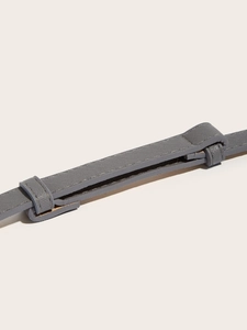 Detailed macro view of grey Saffiano leather belt texture with adjustable loops