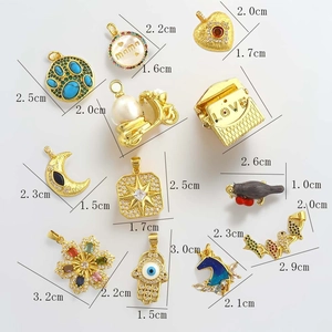 Detailed view of gold charms with zircon inlays featuring flower and moon shapes
