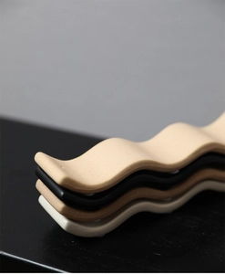 Détail de supports d'encens empilés en céramique avec un design moderne vague en quatre couleurs