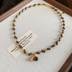 Detailed shot of 18K gold plated tiger eye beaded necklace with sparkling heart pendant