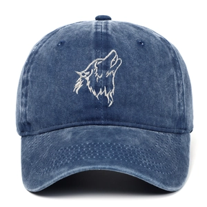 Detailed view of white wolf head embroidery on a vintage washed blue denim baseball cap