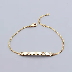 Detail of gold chain bracelet featuring five cubic zirconia gems set in hexagonal bars