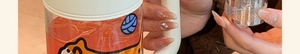 Close-up of a large borosilicate glass tea mug with a handle, lid, and cute stickers