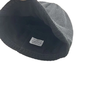 Gros plan sur l'étiquette de composition 100% polyester d'un bonnet noir tricoté