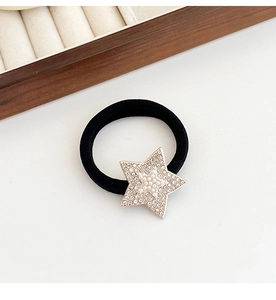 Detail of black elastic hair tie featuring a star charm with pearls and crystals